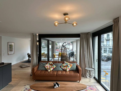 Light-filled living room with balcony access, comfortable seating, and a calm, modern atmosphere to unwind.