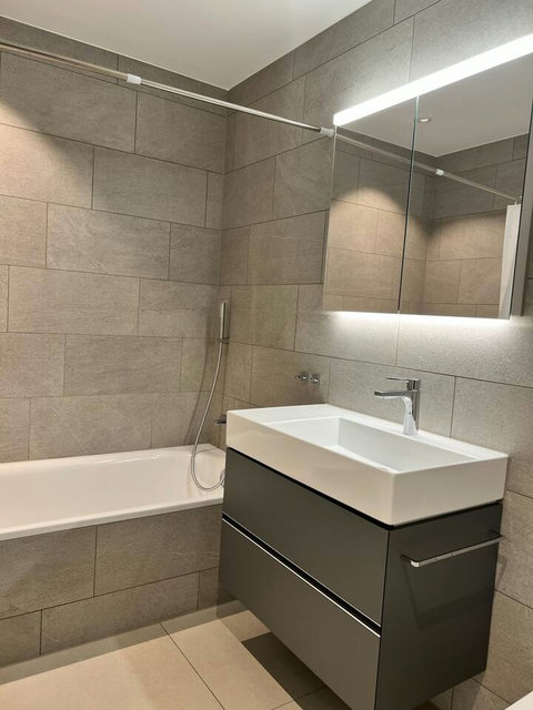 Modern bathroom with bathtub and clean design—perfect for a relaxing soak after a day in the Swiss Alps.