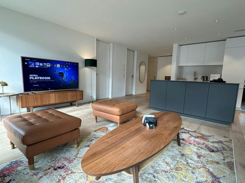 Bright, modern living area with smart TV and open kitchen—perfect for relaxing after exploring Interlaken.