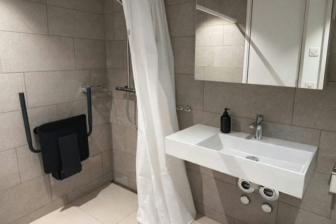 Stylish bathroom with a modern sink, walk-in shower, and sleek fixtures.