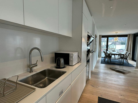 Fully equipped kitchen with a smart layout and clean design, opening toward the dining and living areas.