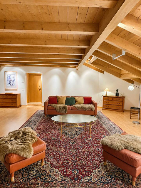 Chalet Swiss Dream Manor lounge — warm wood ceilings, elegant seating and a calm alpine atmosphere for families and friends to relax in style.
