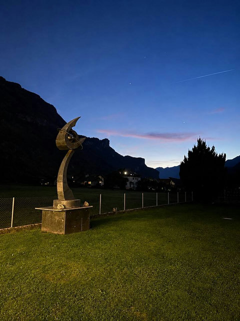 Chalet Swiss Dream Manor garden at twilight — mountain silhouettes, peaceful lawns and magical alpine evenings for unforgettable family moments.