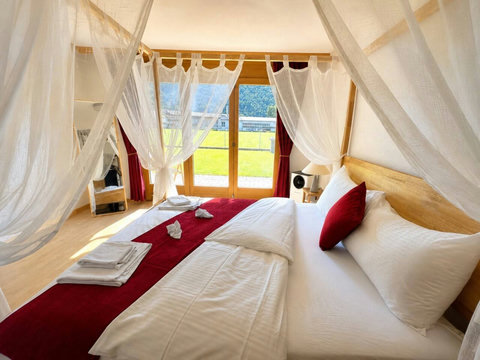 Manor 2 canopy bedroom at Chalet Swiss Dream Manor — romantic draped comfort, garden views and soft alpine light for a lavish Swiss escape.