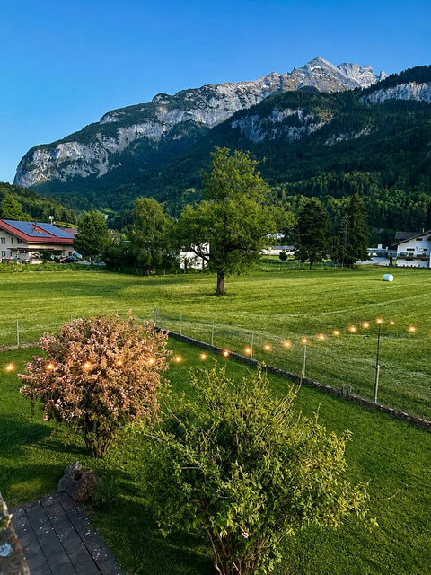 Chalet Swiss Dream Manor garden views — wide green lawns, dramatic alpine scenery and a peaceful Swiss Alps setting for a private luxury escape.
