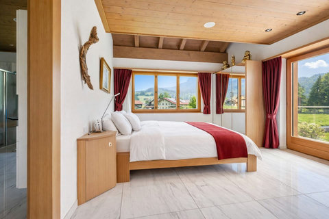 Manor 1 bedroom at Chalet Swiss Dream Manor — spacious, light-filled comfort with warm wood ceilings and Meiringen mountain views for a private Swiss escape.