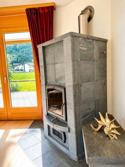 Manor 2 fireplace at Chalet Swiss Dream Manor — cosy alpine warmth, garden access and mountain views for peaceful luxury evenings.