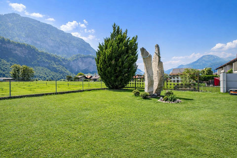 Chalet Swiss Dream Manor garden views — fresh alpine air, wide green lawns and dramatic mountain scenery for a calm luxury Swiss escape.