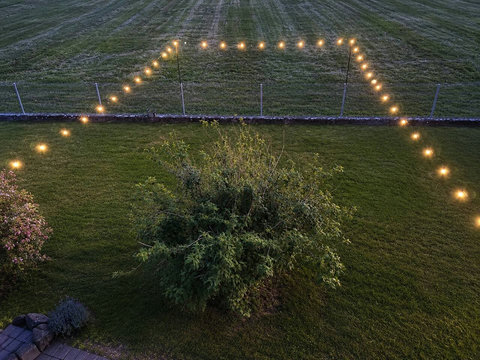 Chalet Swiss Dream Manor garden at dusk — private lawn, glowing lights and fresh mountain air for magical family evenings in Meiringen.