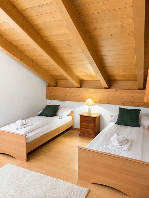 Manor 1 twin bedroom at Chalet Swiss Dream Manor — cosy wood charm, two comfortable beds and calm alpine style for family or friends.