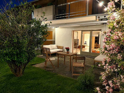 Manor 2 private garden terrace — step-free ground-floor access, outdoor seating and warm evening lights in Meiringen.