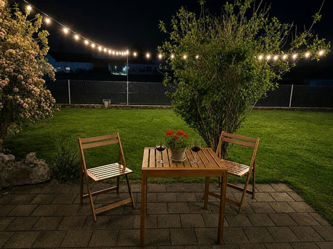 Evening garden dining at Manor 2 — private lawn, alpine air and string lights for peaceful family nights.