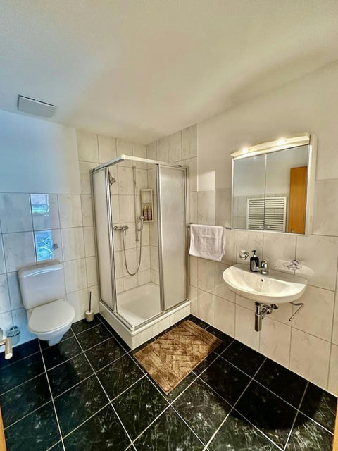 Manor 2 bathroom — step-free ground-floor access with shower, fresh towels and practical comfort for family stays.