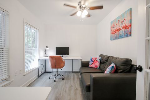 Office contains large desk, couch and standing desk
