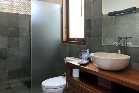 The bathroom is made of stone, so it is usually cooler. It has spacious shower and strong water pressure, including hot water. It is possible to open the window so that it is not damp in it. Big mirror and lot of space to store amenities.