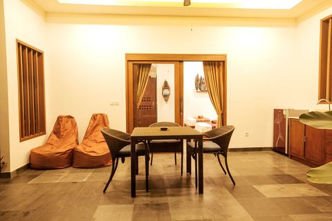 Dining table and comfy two-seater. A dining table can be used for work, if necessary. 
But hey, you are on vacation! 
You can pull out bean bags to the pool deck.