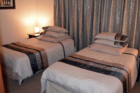 The bedroom softly lit (with pedestal lamps)