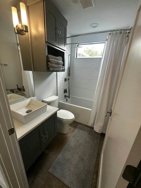 Enjoy a bright, thoughtfully designed bathroom with a full bathtub and shower, contemporary fixtures, and plush towels for a fresh, comfortable experience.