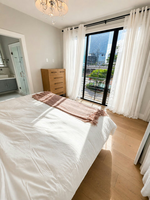 Floor-to-ceiling windows frame downtown Austin views, bringing natural light into this peaceful primary suite with direct access to your private terrace.