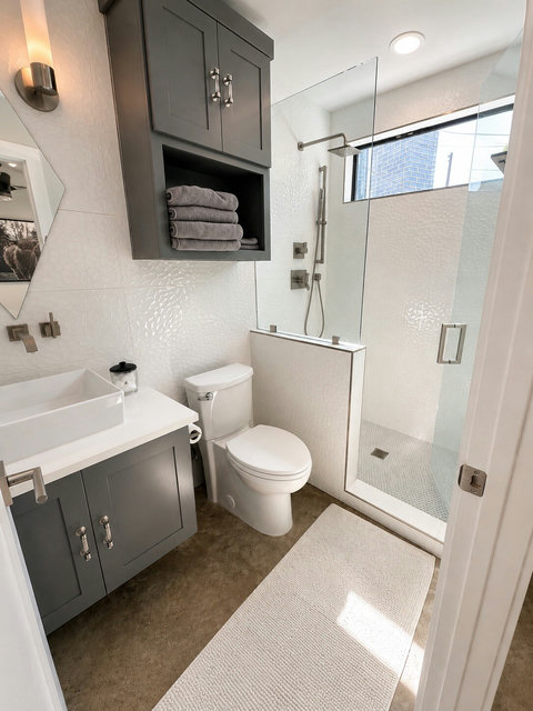 Enjoy a private ensuite bathroom with a spacious glass shower, rainfall showerhead, modern finishes, and thoughtful touches that make getting ready easy and comfortable.