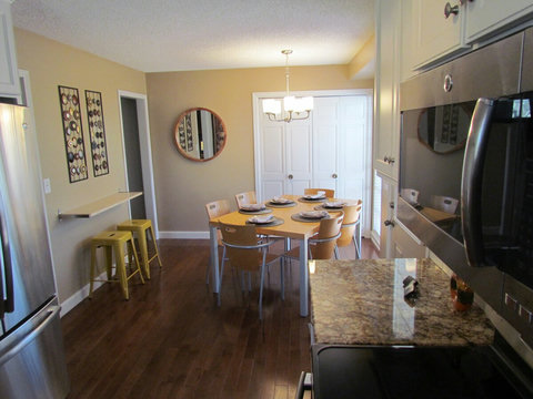 View of dining seating area that seats six, counter with stools and laundry area. Plus partial view of granite countertops.
