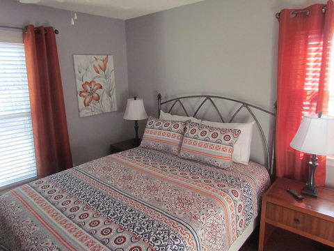 View of queen sized bedroom and reading lamps