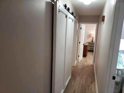 View of barn door that slides of course that covers the washer and dryer conveniently located in the hallway. It cannot be any more convenient than this to do laundry if you need to right in the middle of the bedrooms. 
