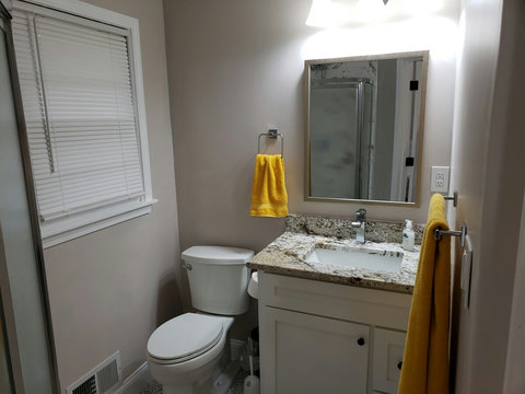 Newly remodeled master bathroom with new tile on floor and shower walls. New vanity has quartz countertop.
