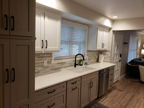 Closer view of sink side of kitchen with trash pull out, pantry and new quiet dishwasher.