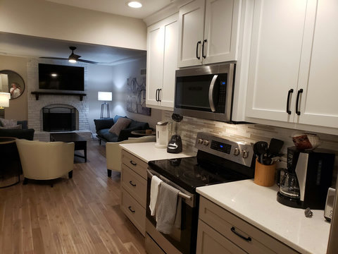 View of the kitchen leading into the living area. Brand new hardwood floors throughout. Open concept to cook and entertain while watching sports, etc. Kitchen cabinets are brand new