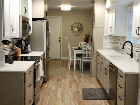 View of new kitchen area with quartz counter tops,  large pantry for guests staying longer, dining area, and door from the garage area. Plus another great view of our beautiful new hardwood floors.