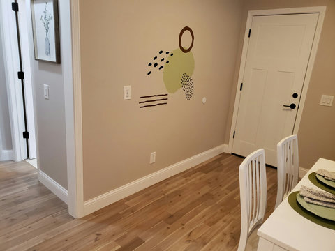 View of garage door entrance, partial view of dining/seating area as well as start of hallway to the bedrooms.