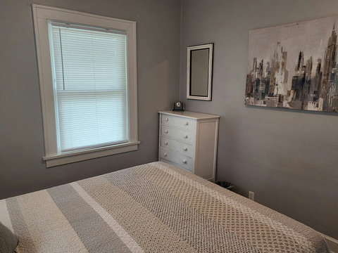 Back queen bedroom with white chest of drawers.