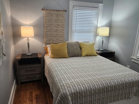 Front queen bedroom with two night stands with usb chargers built in at the back of the cubby hole. Closet has drawers and extra towels.