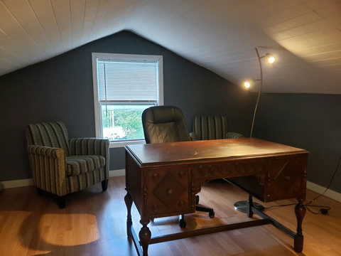 Picture of private office with desk, lamp stand and comfy chairs.