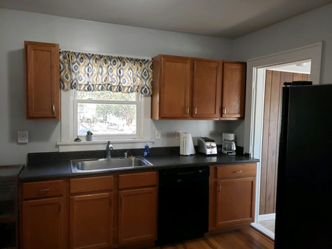 Large sink and countertop with window allowing natural light. Two coffee pots-both regular and Kuerig.