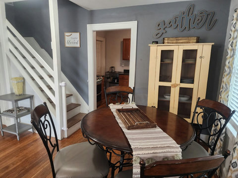 Dining area with cute yellow cabinet, entrance to kitchen and stairs leading up to office. We have a child gate that is easily hooked to keep children or pets downstairs.