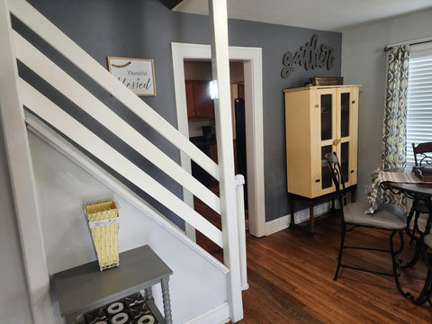 Another angle of dining area and railing of stairs leading up to office/loft area.
