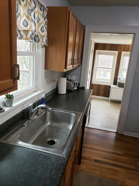 Kitchen counter leading to laundry room/mud room with lots of windows and door to deck.