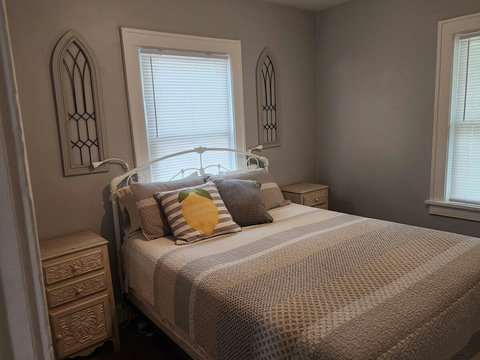 Another view of back queen bedroom that a soft mattress topper. Picture shows Ikea night lights and night stands.