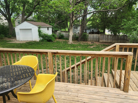 Picture of patio table and chairs over looking large fenced in back yard.