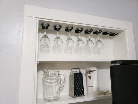 Wine glasses handy to the left of the fridge in the custom built in shelf. Sometimes things get switched out on the bottom shelf.