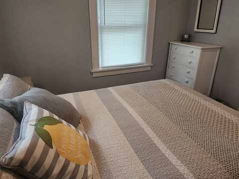 Another angle of back queen bedroom and white chest of drawers