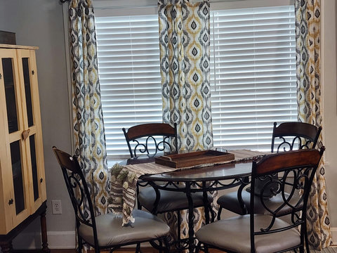 Great comfy seating on the counter height table and chairs with curtains to match along with the vintage yellow cupboard.
