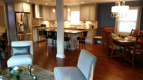 View of kitchen and kitchen island with granite countertops. Partial view of dining room right next to the kitchen and living room seating area when you walk in the front door. 