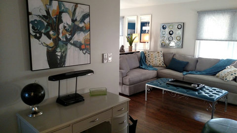 View of desk, sectional and fun metal ottoman