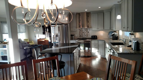 Kitchen view and view of seating area with sectional and tv. 