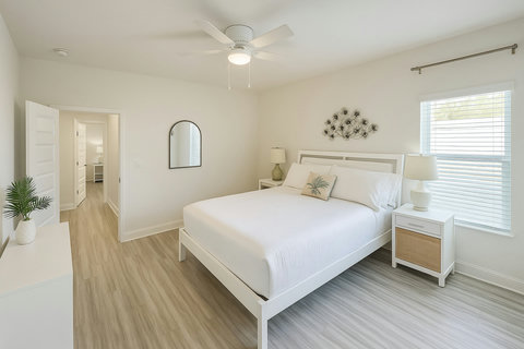 Serene white bedroom with palm accent pillow