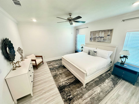 King bedroom with sailboat art and palm lamps