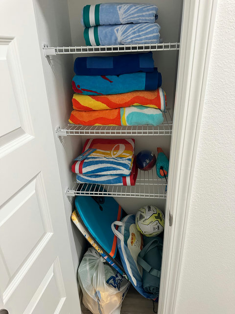 Beach towels, boards, and gear in the closet